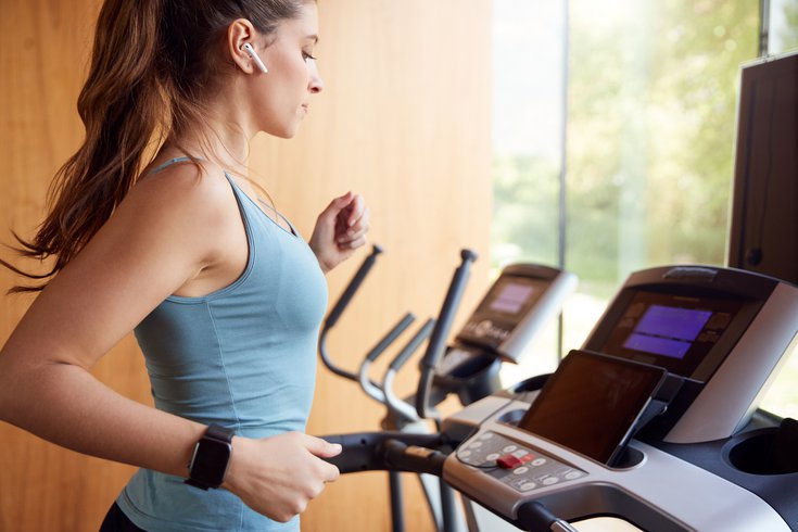 Purchased - woman running on a treadmill watching tablet and using phone