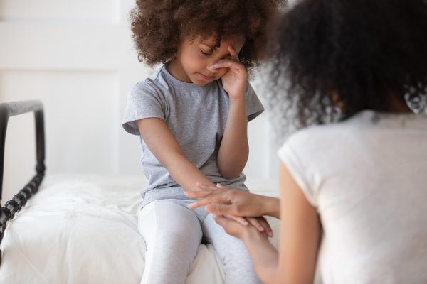 Purchased - Parents comforting a child with growing pains
