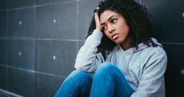 Purchased - Anxious teenager sitting against a wall