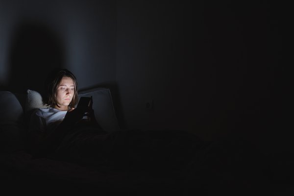 Purchased - Woman on phone late at night in bed