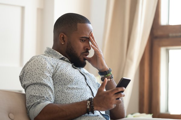 Purchased - Man looking at phone feeling anxious