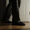Aged man in a pajamas and slippers walks to a bathroom at home
