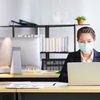 Employee wearing medical face mask while working in the business office
