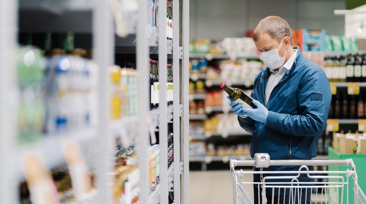 Man picking out wine at a grocery store