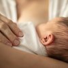 Purchased - Newborn baby girl breast feeding in mothers arms