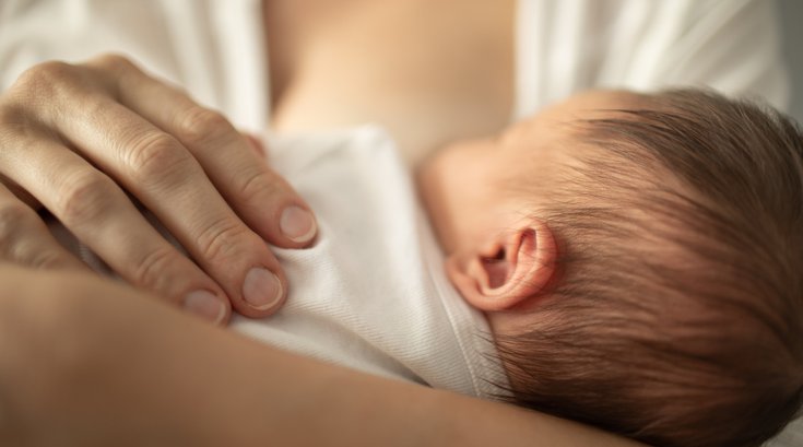 Purchased - Newborn baby girl breast feeding in mothers arms