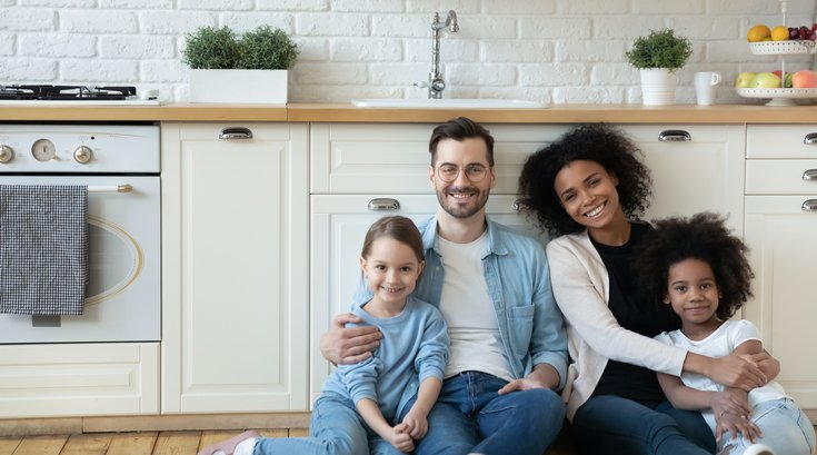 Purchased - couple with daughters sit on floor in kitchen