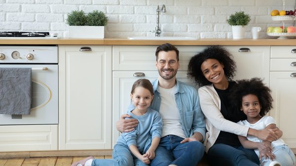 Purchased - couple with daughters sit on floor in kitchen