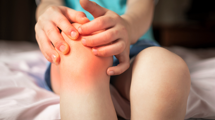 Purchased - Pain in the knee joints of the child. the boy's knees hurt stock photo
