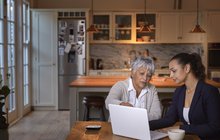 Purchased - Two women discussing information on laptop