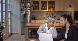 Purchased - Two women discussing information on laptop