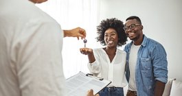 Purchased giving key to the new house to happy young couple