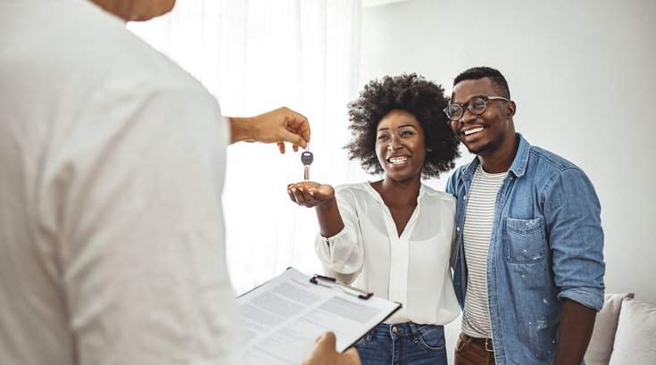 Purchased giving key to the new house to happy young couple