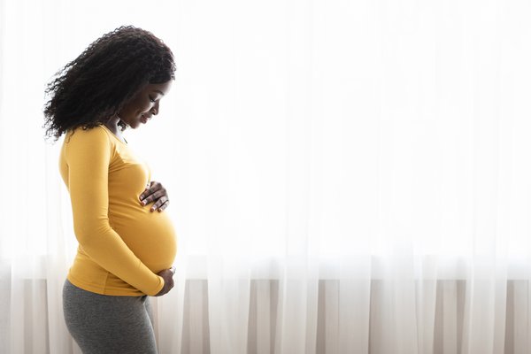 Limited - Pregnant woman looking down at her belly