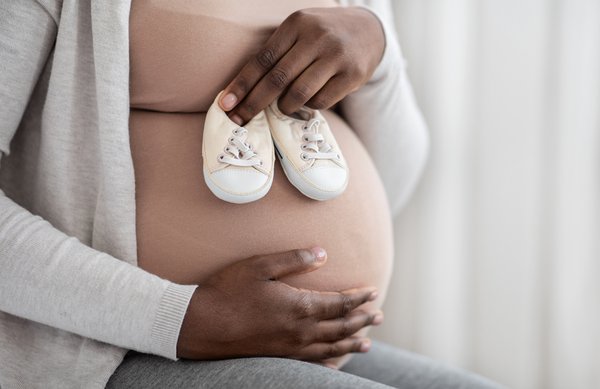 Purchased - Woman Embracing Belly And Holding Small Baby Shoes