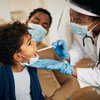 Purchased - doctor with face mask examining boy's throat during a health visit