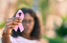 Purchased - Woman holding pink breast cancer ribbon