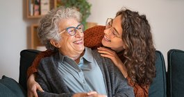 Purchased - Grandmother and granddaughter laughing and embracing at home