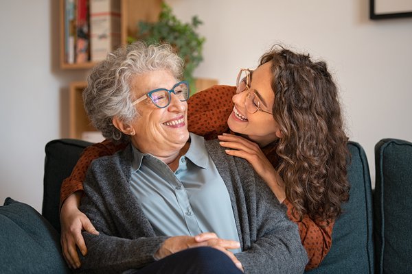 Purchased - Grandmother and granddaughter laughing and embracing at home