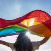Purchased - Young woman waving Pride flag