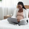 Purchased - Expectant Mother Using Laptop Computer At Home