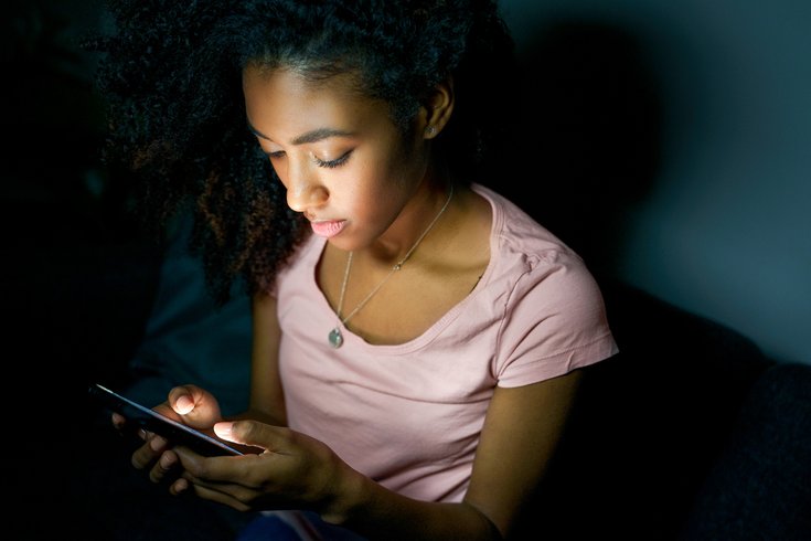 Purchased - teen girl using smartphone at night