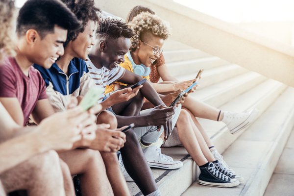 Purchased - students using digital smart mobile phones on college campus