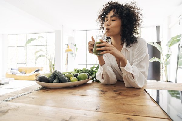Purchased - woman drinking green juice with reusable bamboo straw