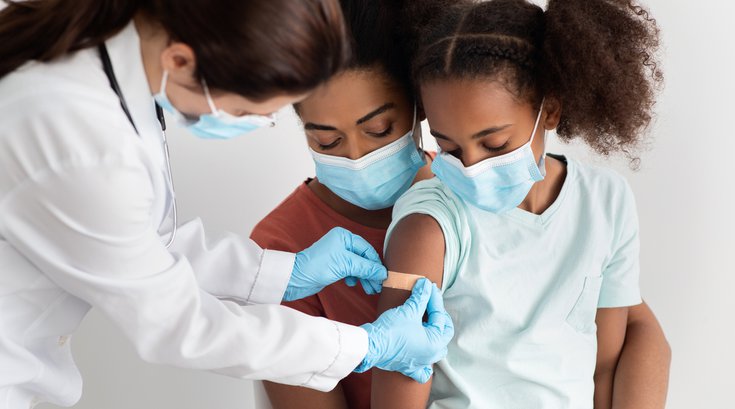 Purchased - child getting a vaccination at hospital, wearing face mask