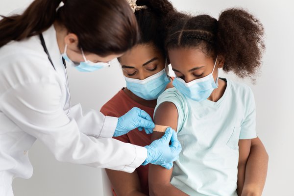 Purchased - child getting a vaccination at hospital, wearing face mask