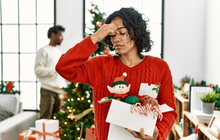 Purchased - woman standing by christmas tree with decoration tired