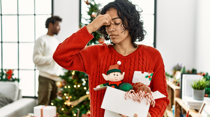 Purchased - woman standing by christmas tree with decoration tired