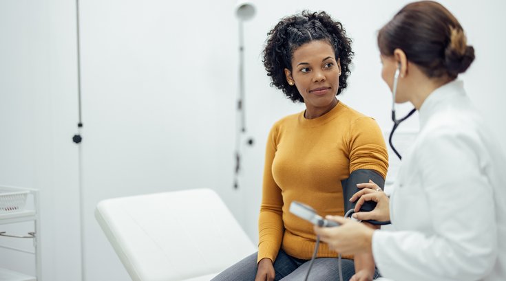 Purchased - woman getting her blood pressure taken at the doctor