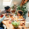 family enjoying in conversation while eating breakfast together at dining table