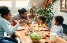 family enjoying in conversation while eating breakfast together at dining table