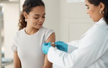 Purchased - A young woman getting vaccinated at the doctor's office