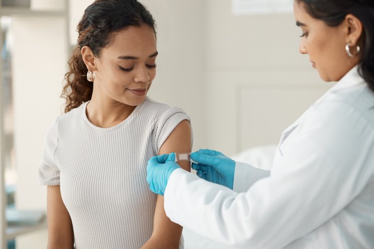 Purchased - A young woman getting vaccinated at the doctor's office