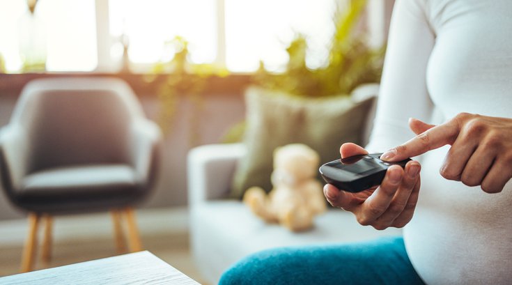 Purchased - Pregnant woman holding device for measuring blood sugar