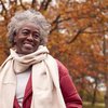 Purchased - an older woman smiling in the park during the fall