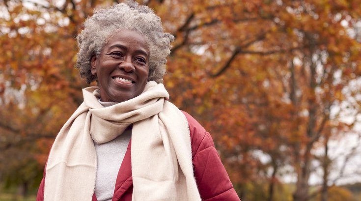 Purchased - an older woman smiling in the park during the fall