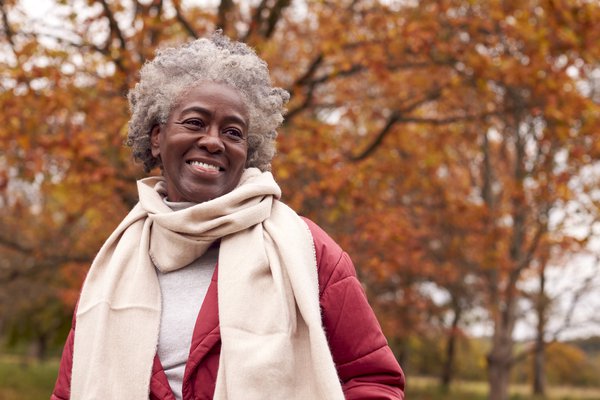 Purchased - an older woman smiling in the park during the fall