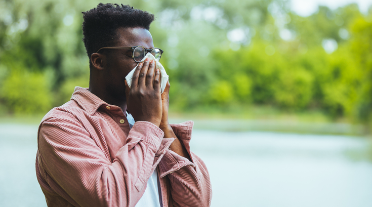 Purchased - A man blowing his nose due to allergic reaction