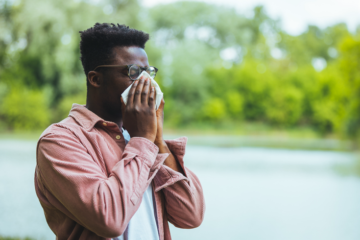 Purchased - A man blowing his nose due to allergic reaction