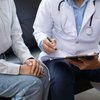 Purchased - Doctor and patient sitting and talking at medical examination at hospital office, close-up