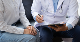 Purchased - Doctor and patient sitting and talking at medical examination at hospital office, close-up