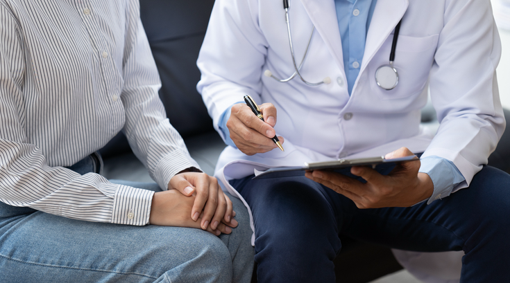 Purchased - Doctor and patient sitting and talking at medical examination at hospital office, close-up