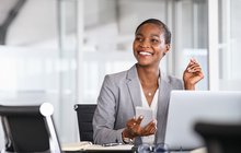 Purchased - Business woman smiling while holding phone