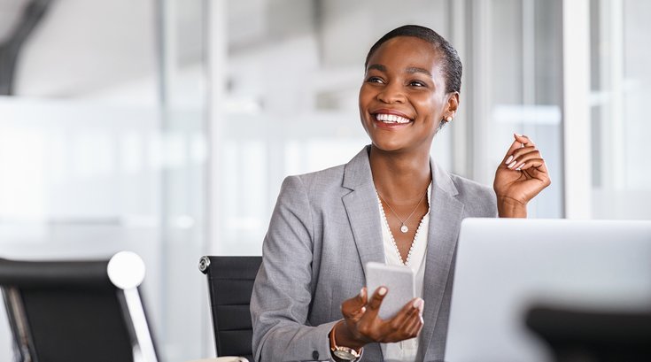 Purchased - Business woman smiling while holding phone