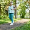 Purchased - Woman Running in Park with Headphones