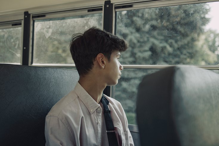 Purchased - Student looking out the window of a bus